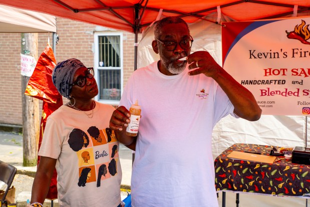 There were vendors at the Juneteenth Marketplace in Lansdowne, including Kevin's Fire Sauce. Kevin's checking the quality of his product with his wife, Jackie. Last names were not supplied. (COURTESY OF STEVEN WEISZ)