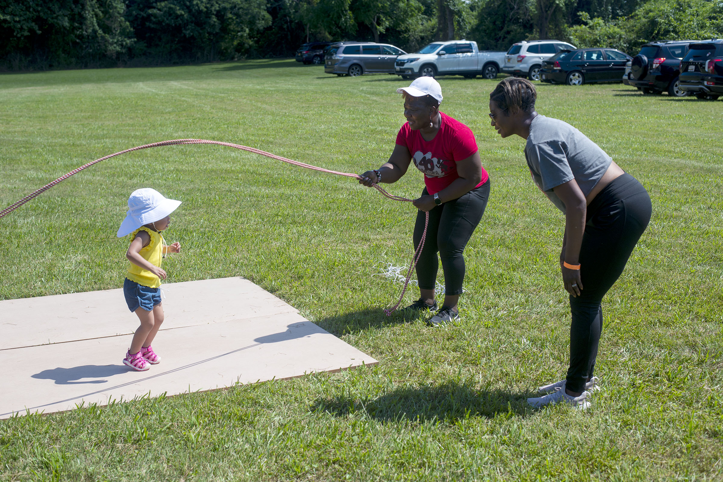 London Bacalja, 3, gets a lesson from Kisha Edwards of the 40 plus Double Dutch Club as her mother Annette Bacalja, right, watches at the 8th Annual Upper Bay Juneteenth Festival in Darlington. (John Gillis/Freelance)
