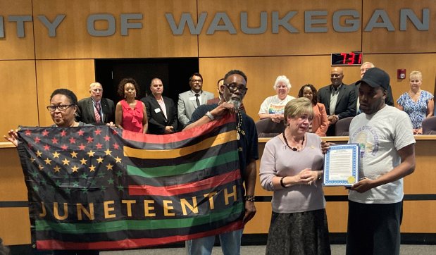 Waukegan Mayor Ann Taylor, second from right, gives a copy of a proclamation honoring Juneteenth to Rayon Edwards, as Harlene Shipley and Clyde McLemore hold a Juneteenth flag at a recent City Council meeting.