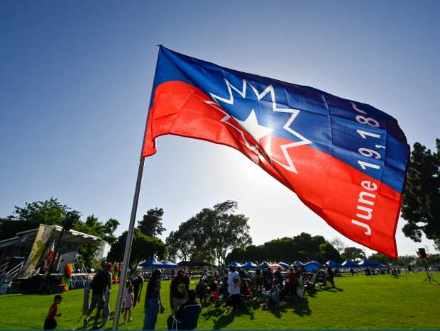 The Juneteenth flag flutters in the wind during the Juneteenth...