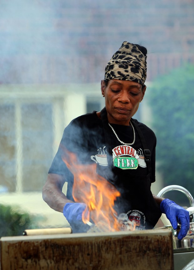 Stacey Burch cooks up hamburgers during Oak Park's Juneteenth community cookout held on the south lawn of Village Hall Saturday, June 15, 2024, in Oak Park. (James C. Svehla/for Pioneer Press)