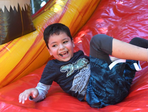 Luis Contreras, 7, plays on the blowup slide on Sunday,...