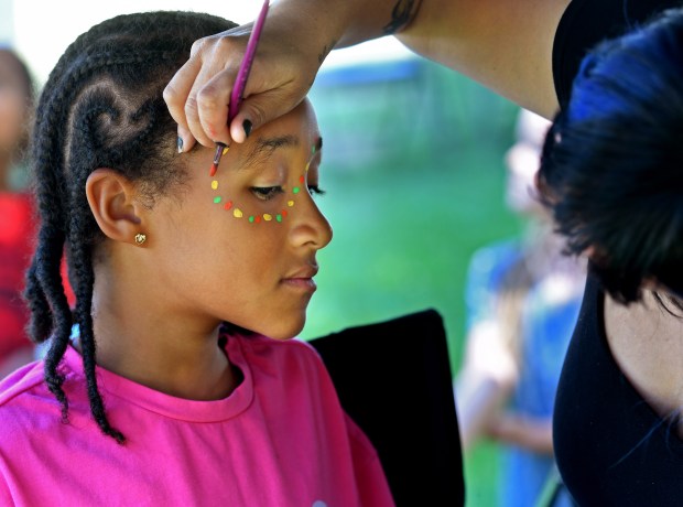 Lakota McBride, 9, gets her face painted on Sunday, June...