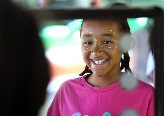 Lakota McBride, 9, looks at the mirror after getting her...