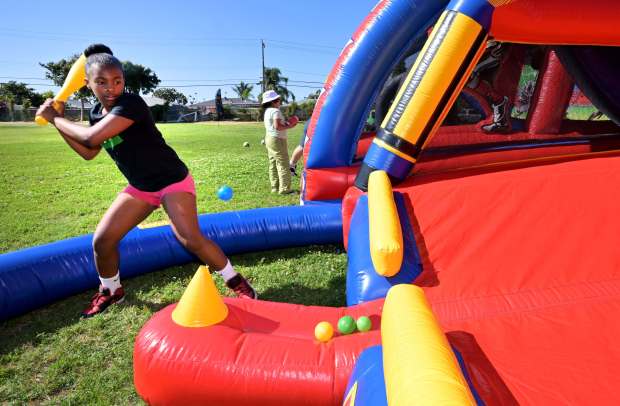 Raven Mayers, 13, swings hard at the inflatable area during...