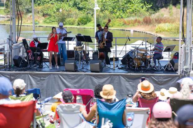 Audience members listen to a band perform at the Juneteenth...
